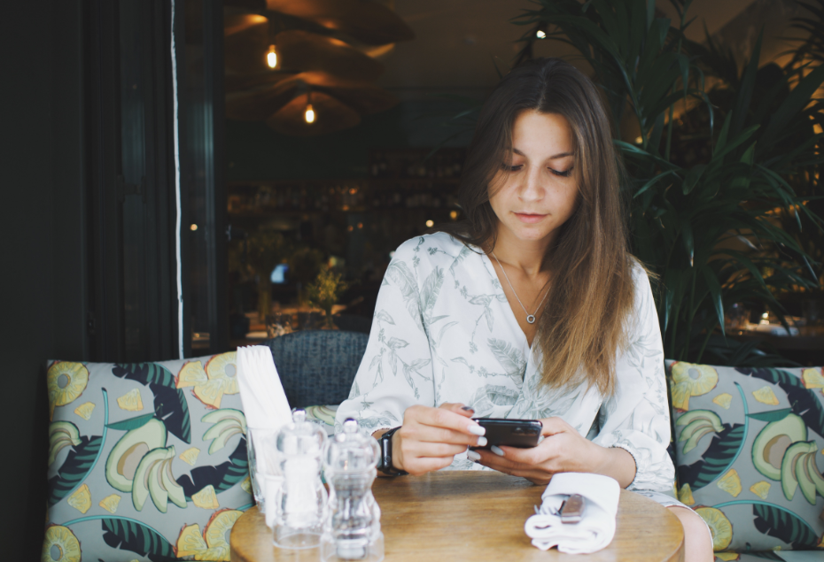 woman-uses-phone-in-cafe-photo-of-food-K3DRNUK